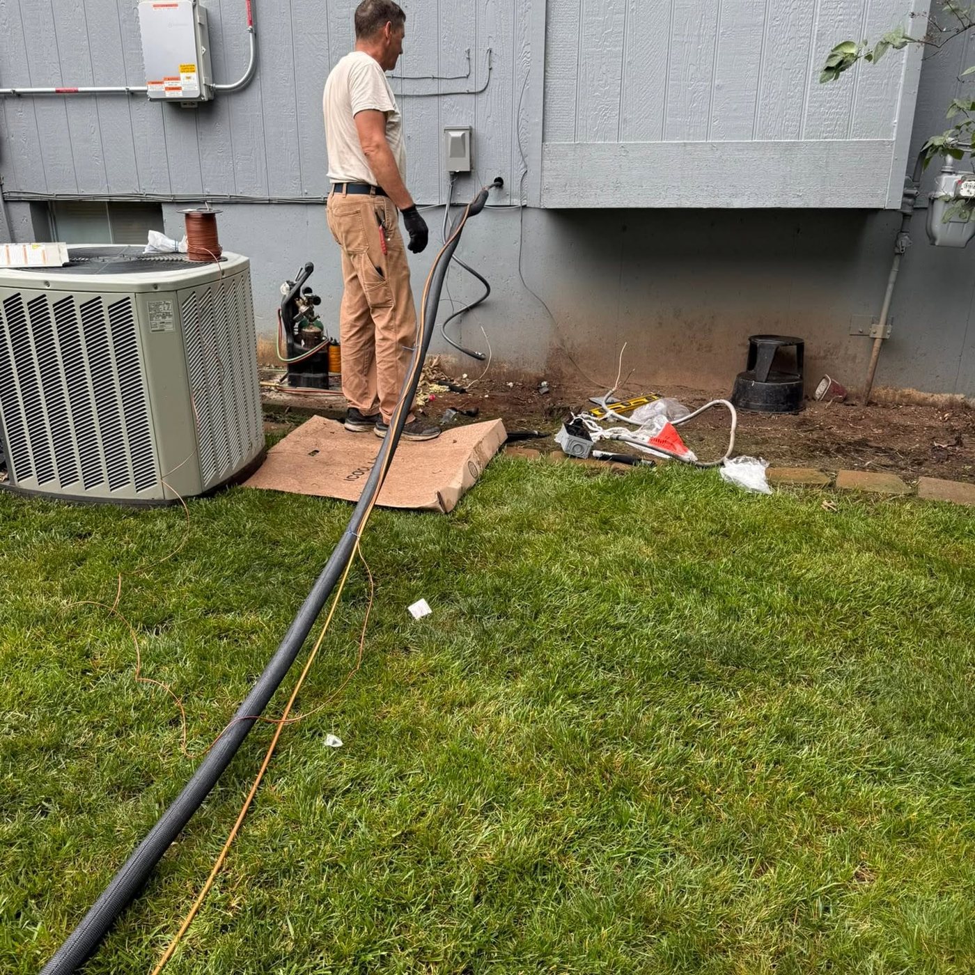 AC line service in progress beside a Kansas City home