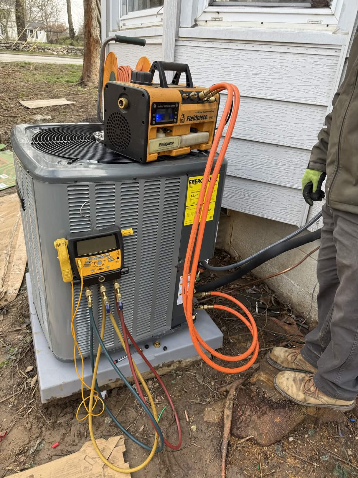 TK Heating & Cooling technician servicing an AC unit